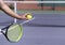 Tennis player with racket and ball on purple hard tennis court prepares to serve. Start of game, match. copy space