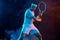 Tennis player with racket in white t-shirt. Man athlete playing on dark background.