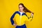 tennis player teen girl in sport wear stand on yellow background. promotions and sale of sport clothes