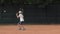 Tennis sportsmanship, ambitious child boy concentrating and focusing on game and racket beats ball on red court