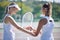 Tennis, trainer and professional female helping a friend with her racket on an outdoor sports court. Supportive, caring