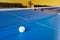 A tennis white ball for Ping-Pong on a blue table. A Ping-Pong game. Sport games