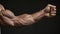 tense arm clenched into fist, veins, bodybuilder muscles on a dark background. Neural network AI generated