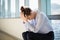 Tense female business executive sitting with hand on forehead