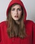 Tensed 20s girl protecting herself in hoodie expressing fear or disagreement