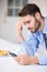 Tensed businessman using mobile phone by table