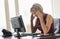 Tensed Businesswoman Looking At Computer At Desk