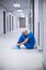 Tensed female nurse sitting in corridor