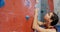 Tensed woman hitting on wall during bouldering 4k