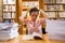 Tensed young woman studying in library