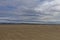 A tensioned wood and wire Fence line crossing the sands of the Tay Estuary at Tentsmuir at Low Tide.