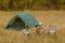 Tent in autumn forest, home for adventure and travel. Family outdoor recreation.