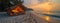 A tent on the beach under the sunset sky with clouds