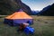 tent, bottles and backpacks in base camp with high snowy mountains in the background, on the trekking of the quebrada santa cruz