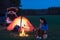 Tent camping car couple sitting by bonfire