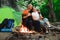 Tent camping couple romantic sitting by bonfire night