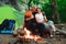 Tent camping couple romantic sitting by bonfire night