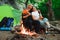 Tent camping couple romantic sitting by bonfire night countryside.