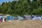 Tent city on meadow at the edge of the forest