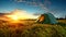 Tent in Field With Setting Sun. Hiking and outdoor recreation