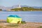 A tent with guarding dog on a beach with with Alcanada Lighthouse Faro de Alcanada in distance.