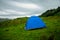 Tent pitched on a green hillside