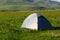 the tent is pitched up to the grass in the field