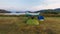 Tent set beside the big lake with beautiful landscape view and a group of birds flying in the blue sky. Idea for relaxing life in