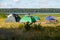 A tent set up in a rugged campsite, at the edge of a lake.Camping colorful tent on the shore of the lake, tourist tent