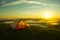 Tent on the top of a mountain with the sunrise