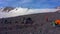 Tents camp in front of Mount Elbrus. Travelers collect their backpacks.