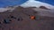 Tents camp in front of Mount Elbrus. Travelers collect their backpacks.