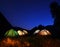 Tents glow at night in the forest