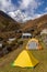 Tents on grass in Machapuchare Base Camp with background of Annapurna South Mountain