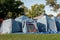 Tents setup for a group camping at the green grass meadow. Multiple instant up connectable tents on a campground