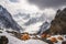 tents and shelters amid towering mountain peaks, surrounded by dramatic snowy landscape