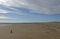 Tentsmuir Point at Low tide with a small wooden weathered marker on the foreshore of the wide sandy beach.