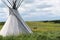 Tepee or Tipi with horses in the background on a Montana plain with blue sky