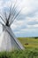 Tepee or Tipi with horses in the background on a Montana plain with blue sky