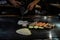 teppan show at a traditional Japanese restaurant. hands of the cook. Japanese cook prepares meat, fish, rice, vegetables