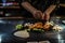 teppan show at a traditional Japanese restaurant. hands of the cook. Japanese cook prepares meat, fish, rice, vegetables