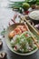 Teppanyaki fried rice with shrimp, mushrooms, green onion, pepper and herbs on light concrete background, asian food, healthy life