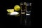 Tequila gold and silver in glasses, lime and salt. On a black background