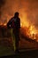 Teralba, NSW/Australia - October 24, 2012: Close up of fireman supervising the backburning and extinguishing a wildfire grass and