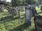 TERESVA, UKRAINE, SEPTEMBER 18, 2017; An old Jewish cemetery. Shattered gravestones stand among the green grass. On them - inscrip