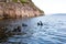 Teriberka, Russia - July 29, 2017: Three scuba divers floating on the surface of the sea.