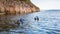 Teriberka, Russia - July 29, 2017: Three scuba divers immersing into the water