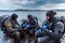 Teriberka, Russia - July 29, 2017: Three scuba divers sitting in the boat, checking their equipment and preparing to dive. Shot in