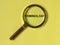 Terminology word through magnifier on bright yellow background, top view