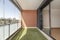 Terrace with glass wall, artificial grass floor and painted iron railing